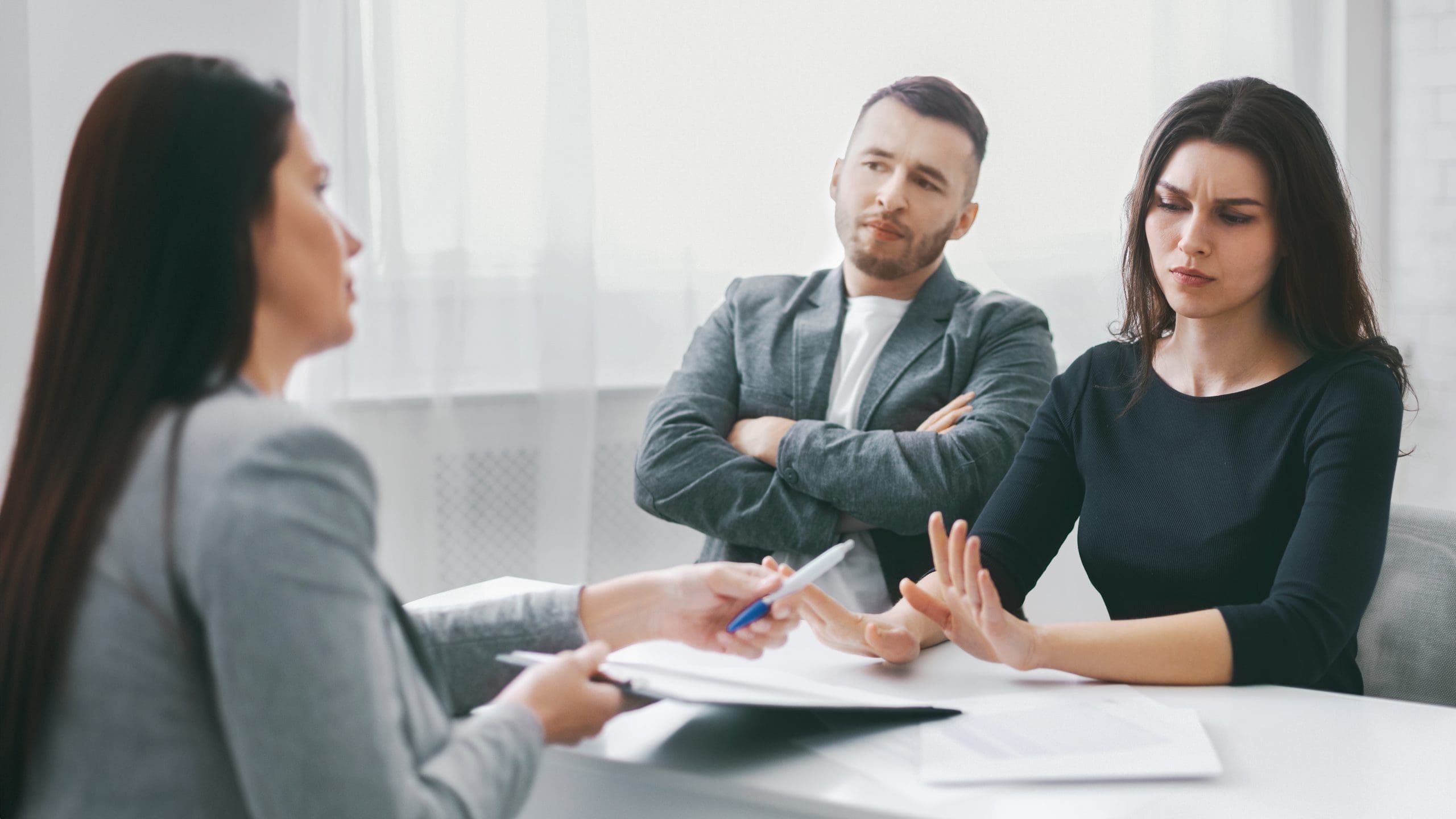 an upset couple meeting with a lawyer in an office