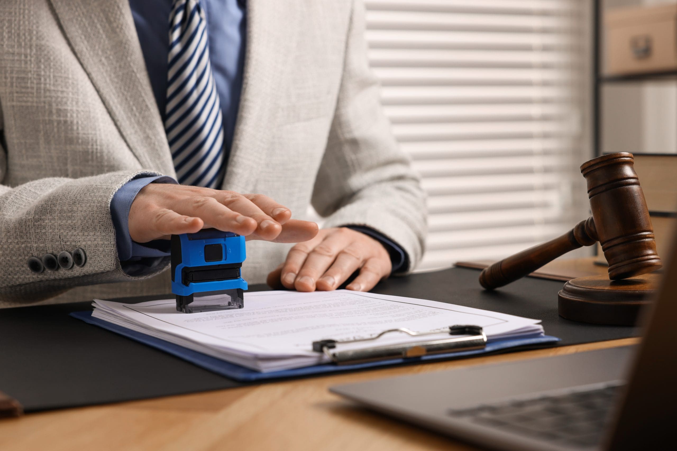 a notary stamping a document at a table in an office, close up