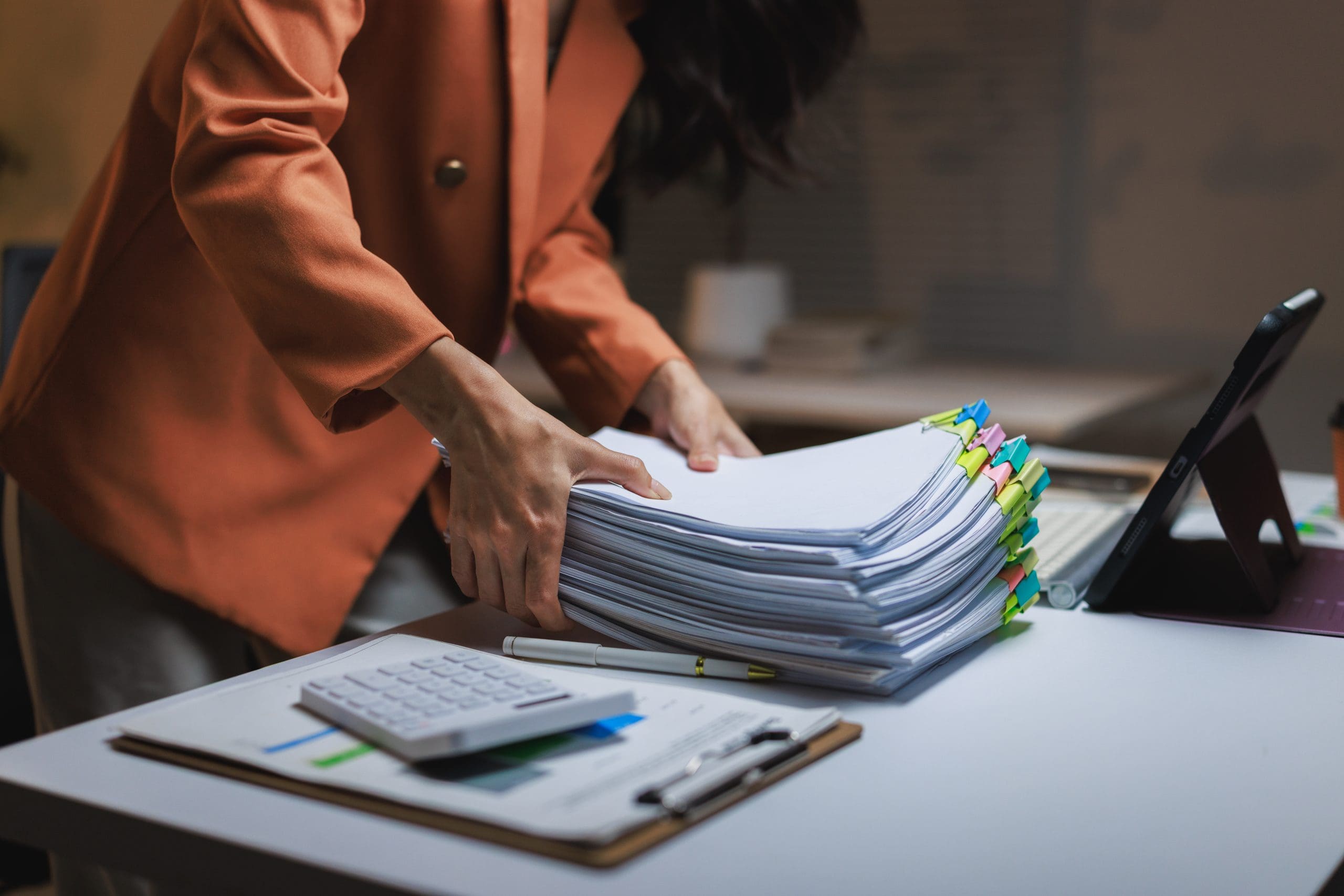 a businesswoman organizing financial paperwork in an office