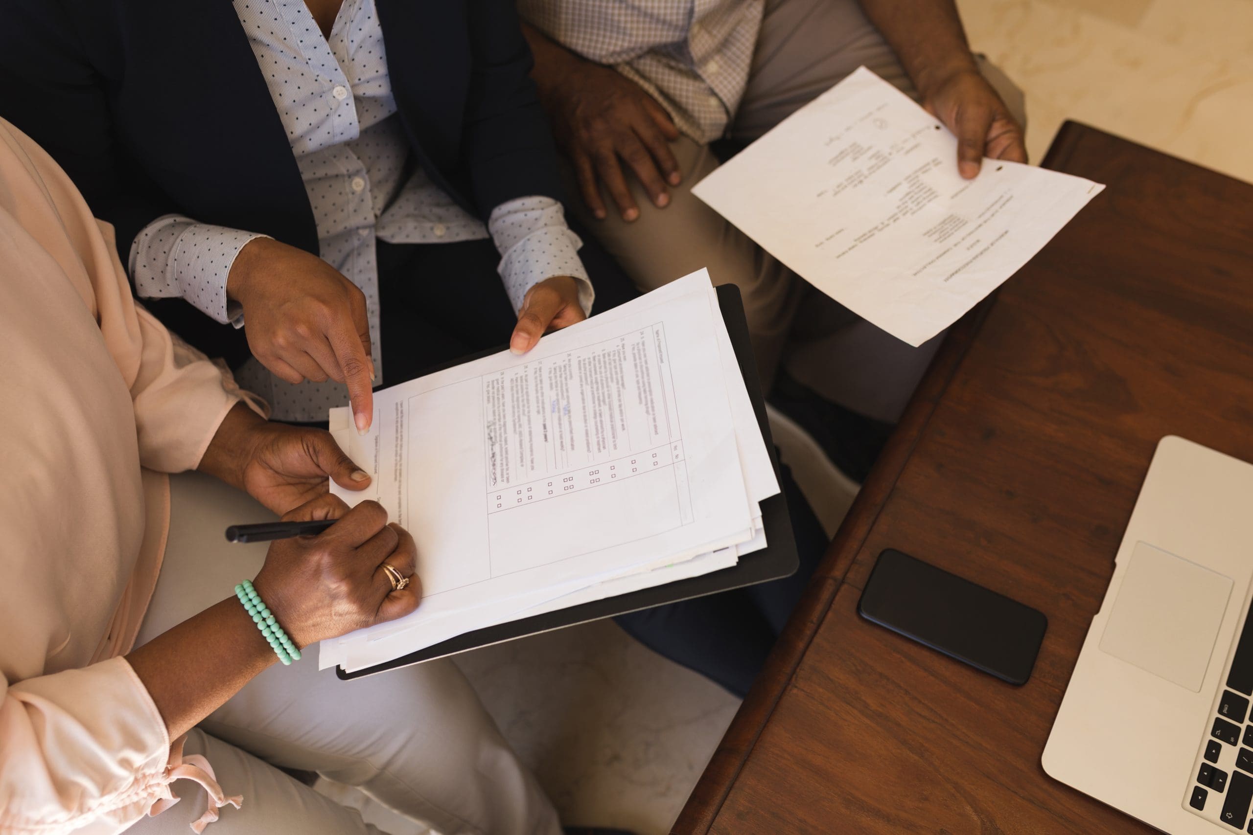 an older couple signing documents at home on the sofa 