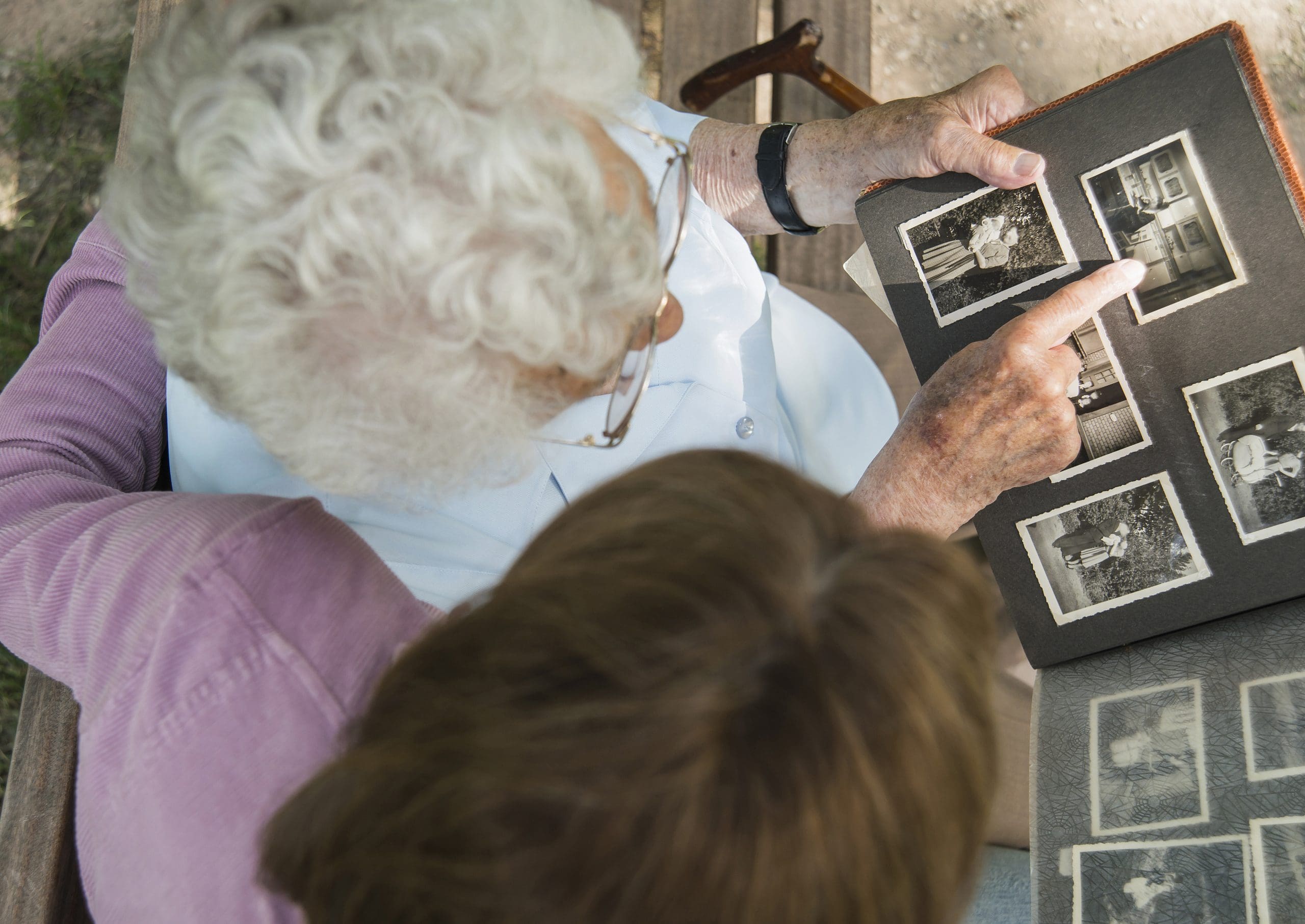 a grandmother and granddaughter looking at a photo album together